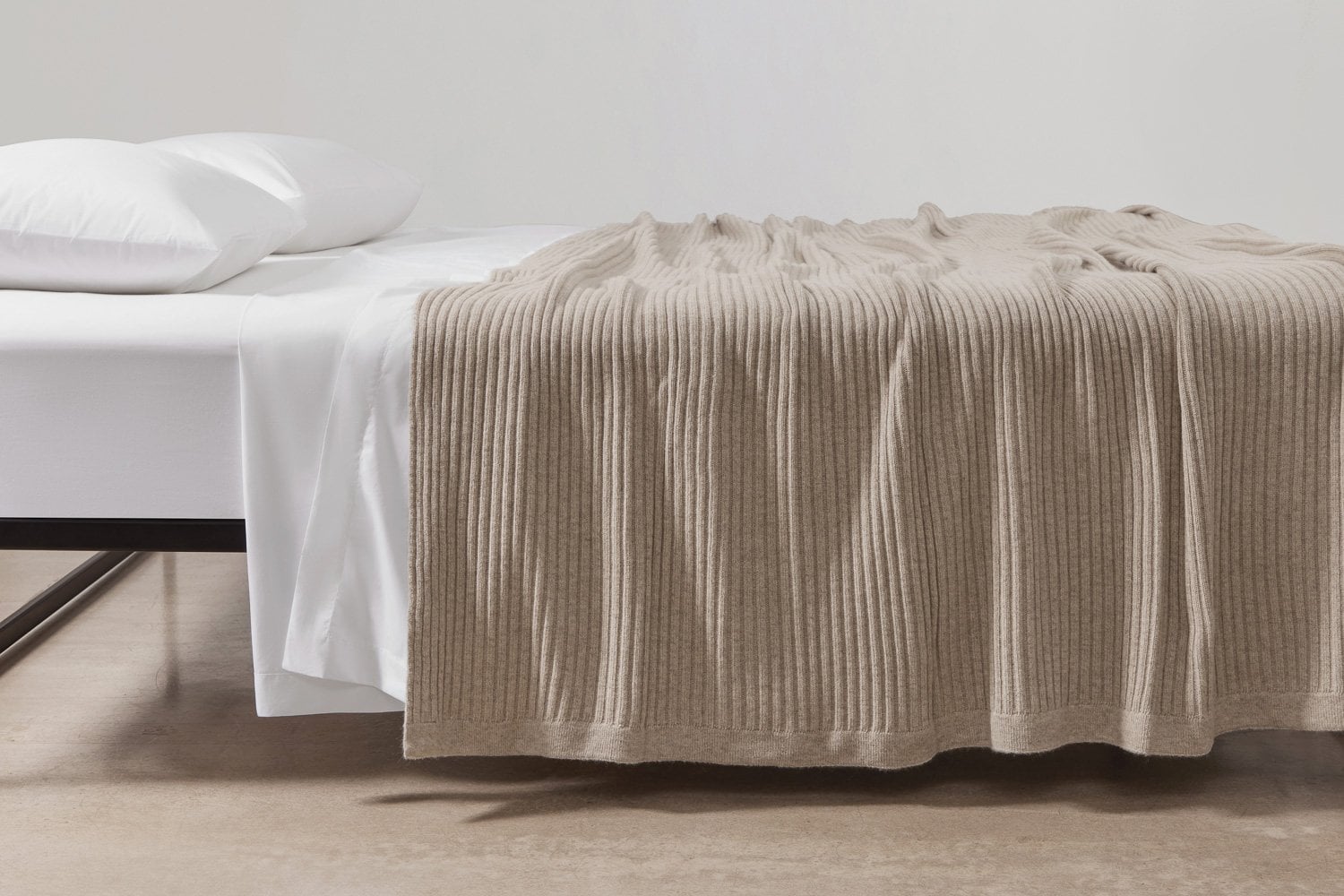 Angora and merino wool wide rib blanket in wheat color layered over crisp percale cotton sheeting, highlighting a cozy and elegant bedroom setting.