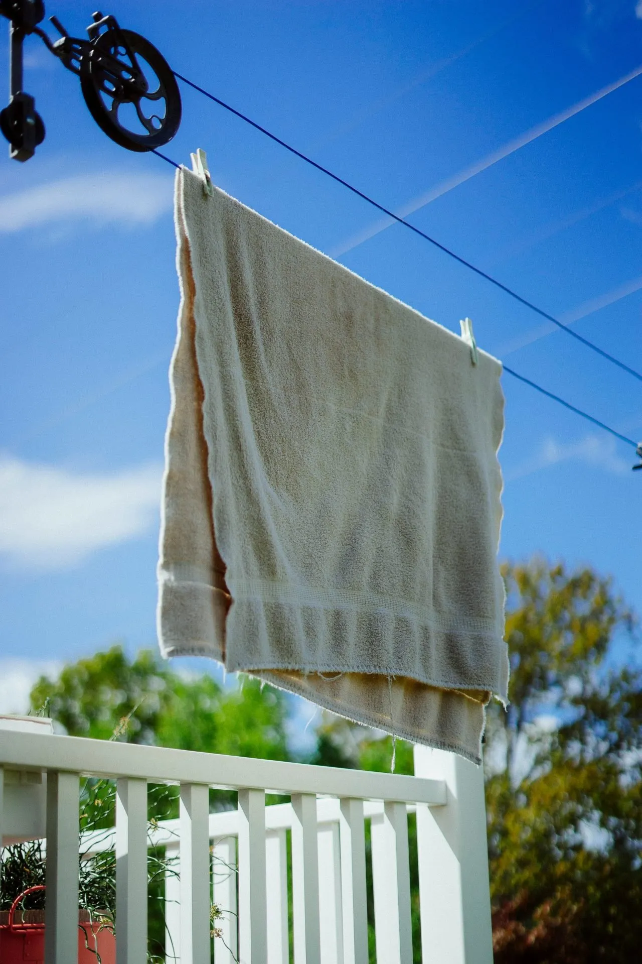 Bath towel drying on an outdoor clothesline in warm weather