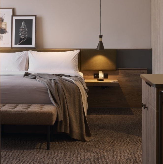 Rydges Melbourne bedroom with warm lighting and a bemboka Reversible Rib pure cotton blanket on the bed.