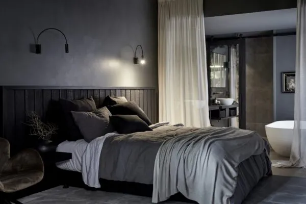 Contemporary bedroom styled for winter with layered bedding, a soft throw, warm lighting, and neutral tones creating a cosy and inviting retreat.