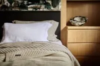 Natural fibre bedding layered with a soft wool blanket in a calm, contemporary bedroom designed for comfort and restful sleep.