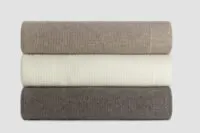 Folded Chain Rib Angora and Merino wool blankets in soft neutral shades, showcasing the fine ribbed knit and luxurious natural fibres.